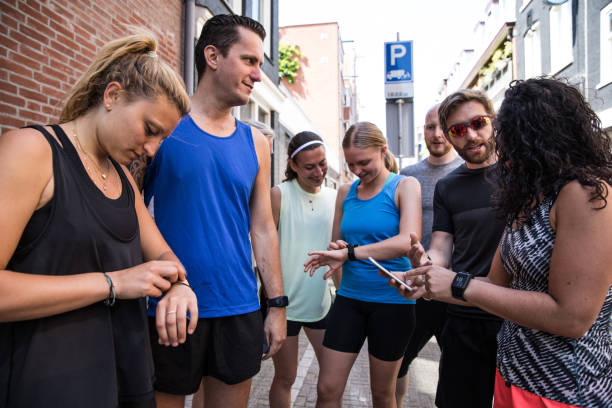 grupo de equipe sportive dos corredores na cidade de amsterdão - checking the time fotos - fotografias e filmes do acervo