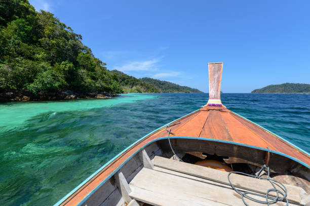 istock Wooden long-tail boat sailing on tropical sea 1142844530