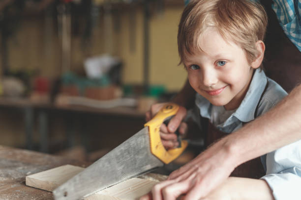 istock Father and a little son sawing a board 1142844917