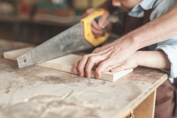 istock Father and son sawing a board 1142845029