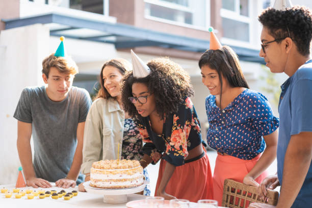 十代の誕生日の女の子吹いケーキキャンドル - birthday family party cake ストックフォトと画像