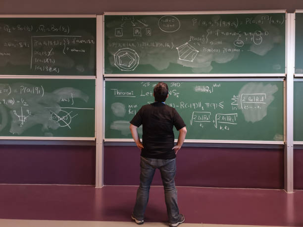 jeune mathématicien regarde la formule sur le tableau noir - formula blackboard complexity scientist photos et images de collection