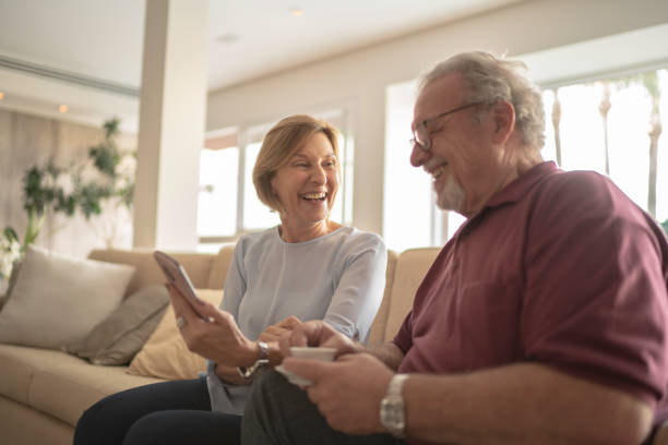 seniorenpaar lachen beim smartphone - women telephone senior adult on the phone stock-fotos und bilder