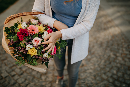 Young walking city streets with flower bouquet