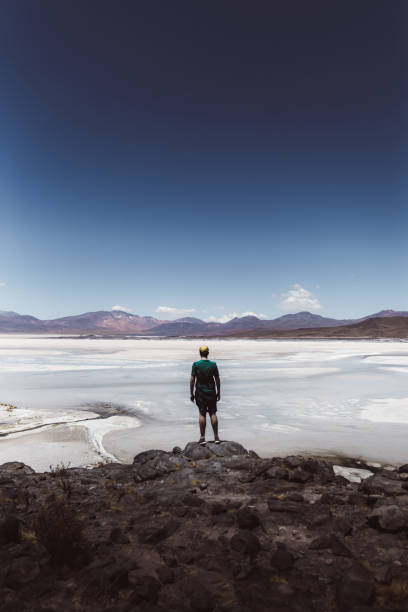 istock Man exploring salt flat and volcanic landscape in Atacama desert 1142849829