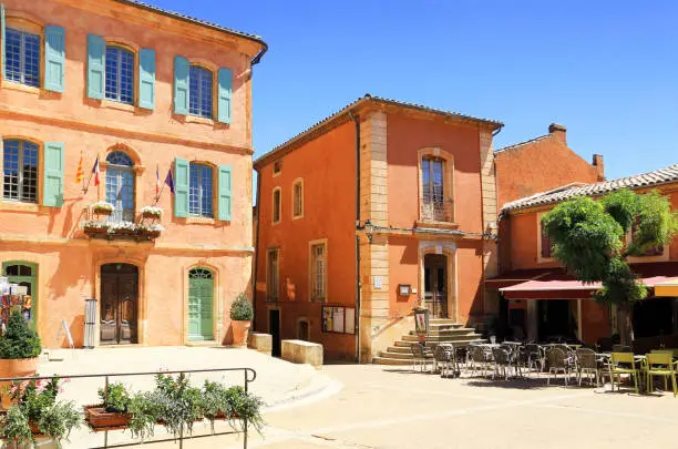 Photo of Ocher facades on the Roussillon square in Provence, France.