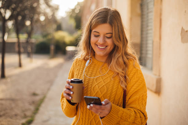 istock Girl with in-ear headphones using phone 1142854150