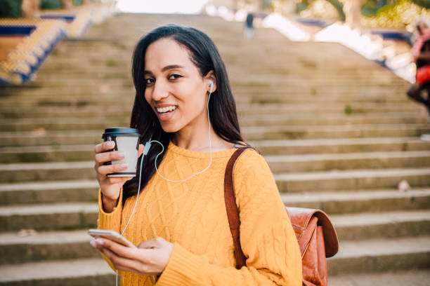istock Girl with mobile phone drinking coffee 1142856138