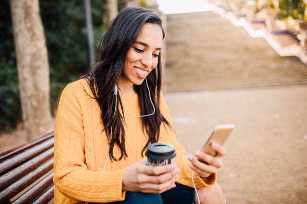 chica feliz sosteniendo el teléfono y el café para ir - city street audio fotografías e imágenes de stock