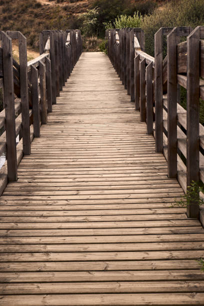 Old wooden bridge rises a river on a quiet and lonely cloudy day