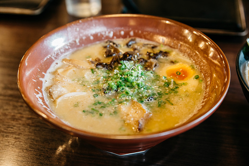 Close up of Ramen Pork Bone Soup (Tonkotsu Ramen) with Chashu Pork, Scallion, Sprout, Corn, Dried Seaweed and boiled eggs.