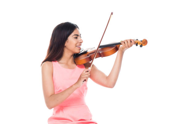 istock Attractive young latino female playing the violin while sitting on stool 1142858720