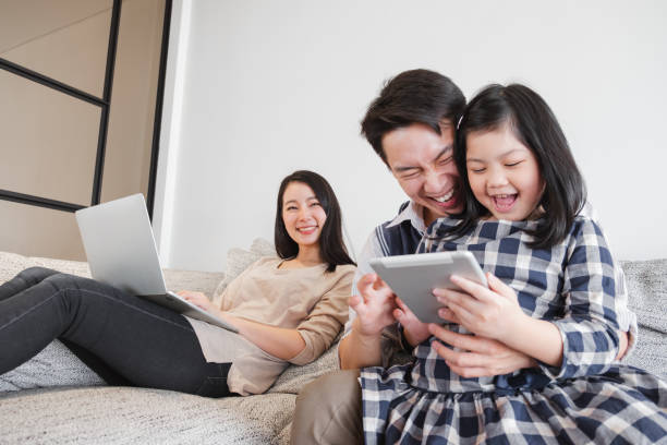 happy asian family spending time together at home playing game, tablet for education - father digital tablet asian ethnicity daughter imagens e fotografias de stock