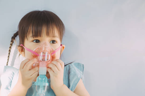 kind erkrankte an asthma oder lungenentzündung, die sich auf das gesundheitssystem der atemwege auswirkten. - asthmatic child asthma inhaler inhaling stock-fotos und bilder