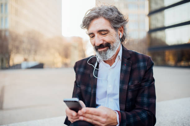 istock Man smiling when listening podcast via mobile phone 1142860047