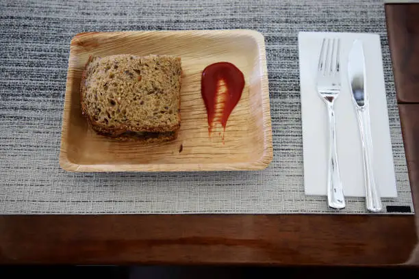 Whole wheat bread sandwich on foam tray and tomato sauce With knives and plastic forks For serving on a private jet