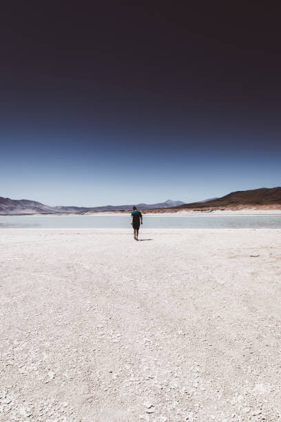 istock Man walking at salt flat in Atacama desert 1142863075
