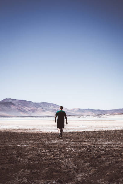 istock Man walking at salt flat in Atacama desert 1142865387