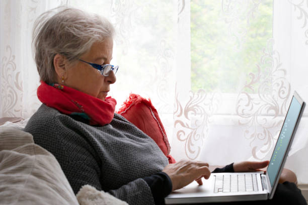 donna anziana che usa il laptop. - senior adult independence lifestyles home interior foto e immagini stock