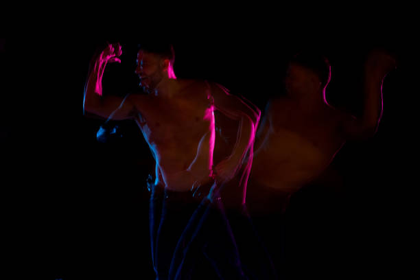 istock Shirtless man dancing with color gel lights 1142866842