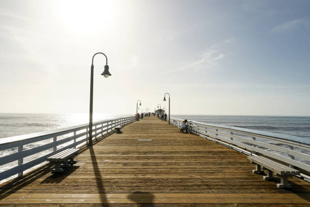 San Clemente Pier during beautiful blue summer day. San Clemente beach in Orange County, California, USA. Travel destination in the South West coast. Sunset color reflection over the water.