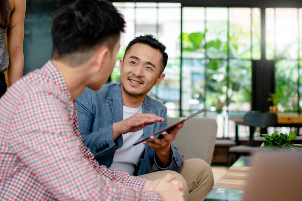 Coworkers having an informal meeting in a modern office Coworkers having an informal meeting in a modern office. Hong Kong 2019 asian and indian ethnicities stock pictures, royalty-free photos & images