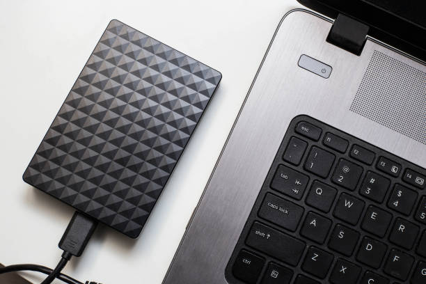 istock External hard drive connect to laptop computer, transfer or backup data between laptop and hard disk 1142874917