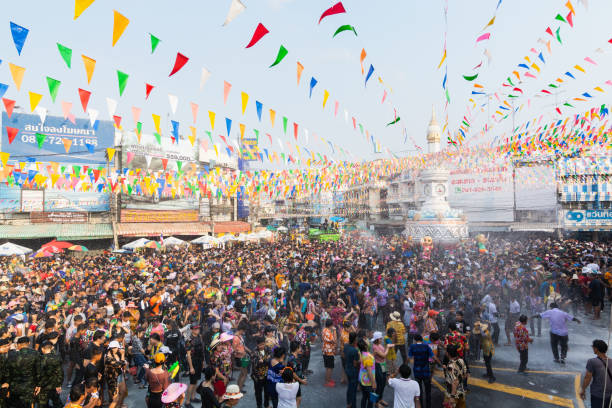タイの人々、スコータイの路上で新年のソンクラーン水祭りを祝う - wet dress rain clothing ストックフォトと画像