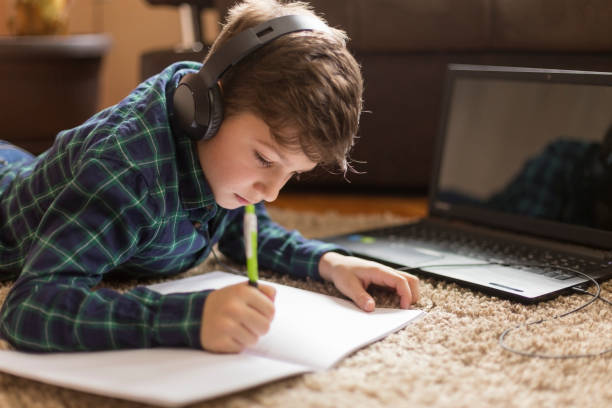 istock Young boy listening to music while doing homework 1142876886
