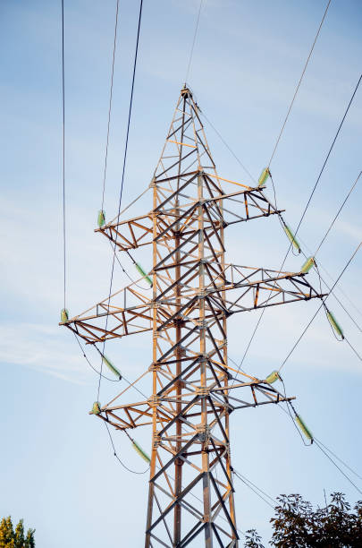 istock Electric pole with high-voltage wires against the blue sky. 1142878136