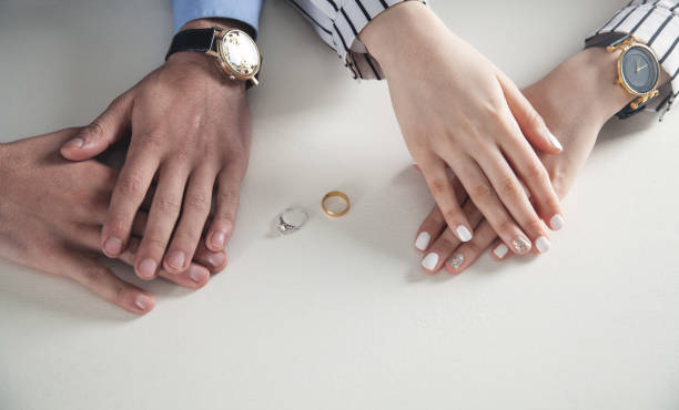 istock Man and woman hands with ring on desk. 1142882051