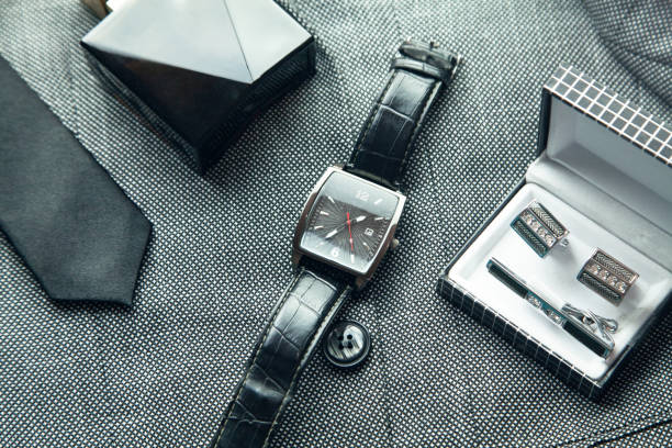 istock Cufflinks, wristwatch, perfume, tie in suit background. 1142882082