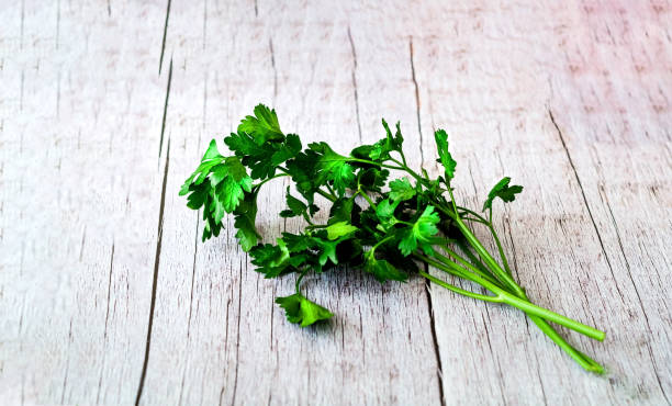 istock Fresh parsley leaves on old wooden background. 1142883232