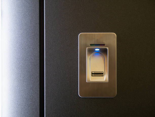 istock closeup fingerprint sensor on modern armored metallic black door and blue light led indicator 1142883634