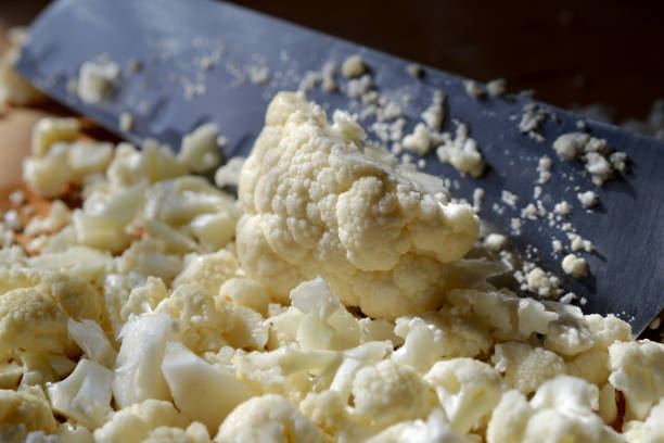 istock Cauliflower being chopped with a knife on cutting board. 1142885162