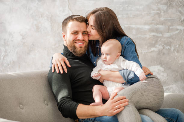 istock Happy family with infant sit at sofa 1142885514