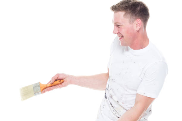 istock Young male painter with stained clothes on white background - showing to the side 1142890674