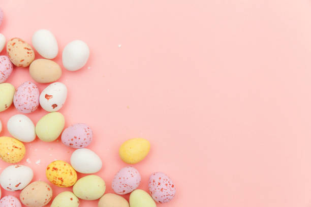 istock Happy Easter concept. Easter candy chocolate eggs and jellybean sweets isolated on trendy pastel pink background. Simple minimalism flat lay top view copy space 1142890705