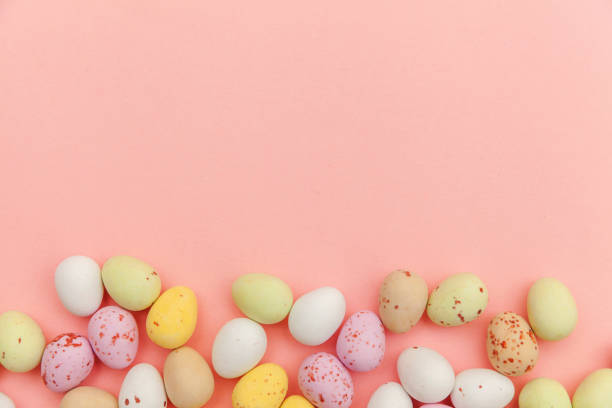 istock Happy Easter concept. Easter candy chocolate eggs and jellybean sweets isolated on trendy pastel pink background. Simple minimalism flat lay top view copy space 1142890849