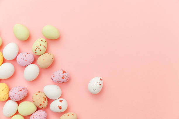 istock Happy Easter concept. Easter candy chocolate eggs and jellybean sweets isolated on trendy pastel pink background. Simple minimalism flat lay top view copy space 1142890947