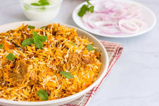 Chicken Biryani In a Bowl Served with Onion, Yogurt and Mint