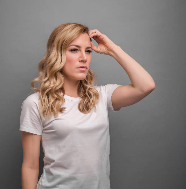 istock A woman thinks holding her head or has a headache. 1142892184