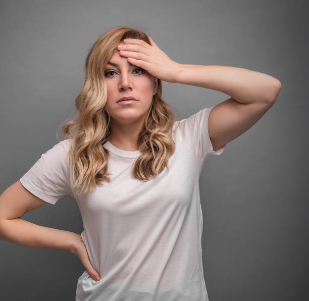 istock A woman thinks holding her head or has a headache. 1142892195