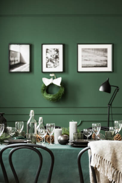 istock Wine glasses, candles and plates on table covered with green tablecloth 1142893451