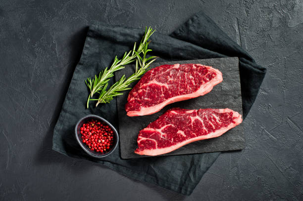 Steak of marbled beef black Angus. Black background, top view.
