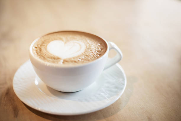 istock White cappuccino cup on light brown wood background 1142894969