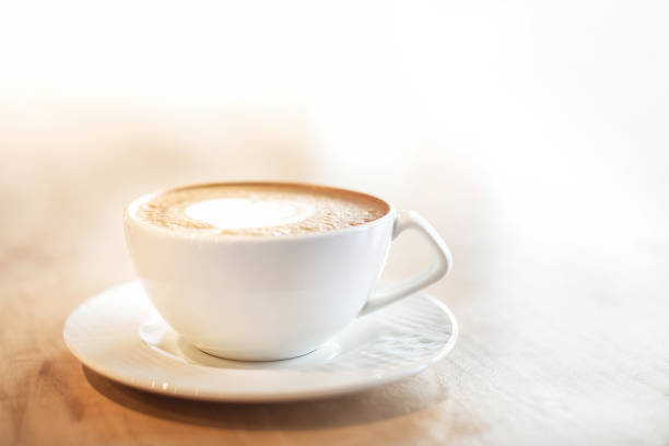 istock White cappuccino cup on light brown wood background 1142894976