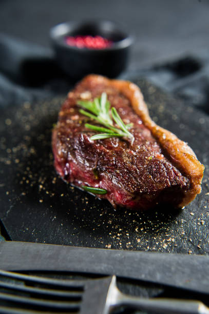 istock Sirloin beef steak with rosemary. Black background, top view. 1142895100