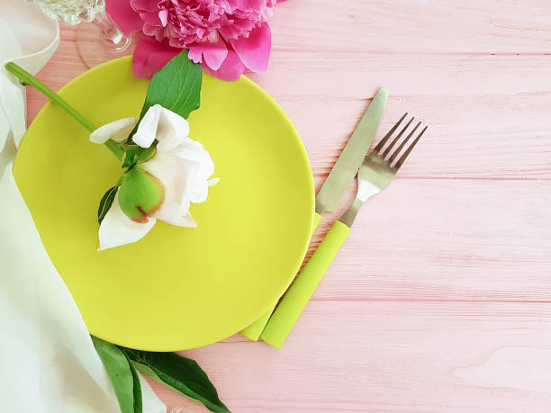 istock peony flower plate on pink wooden background 1142895309