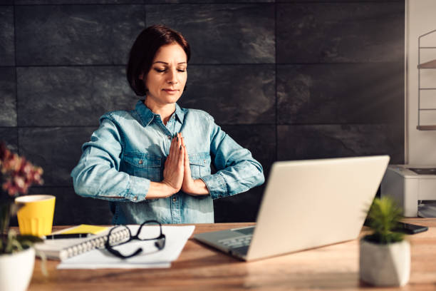 istock Business woman meditating at work 1142896164